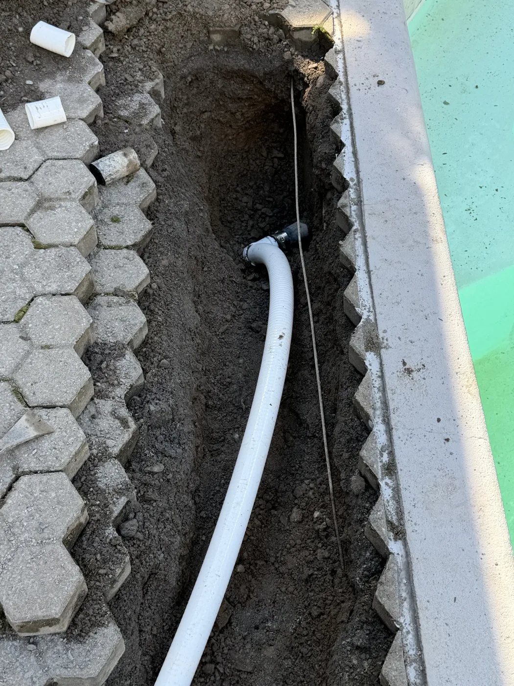 Ligne de tuyauterie de piscine exposée le long du bassin